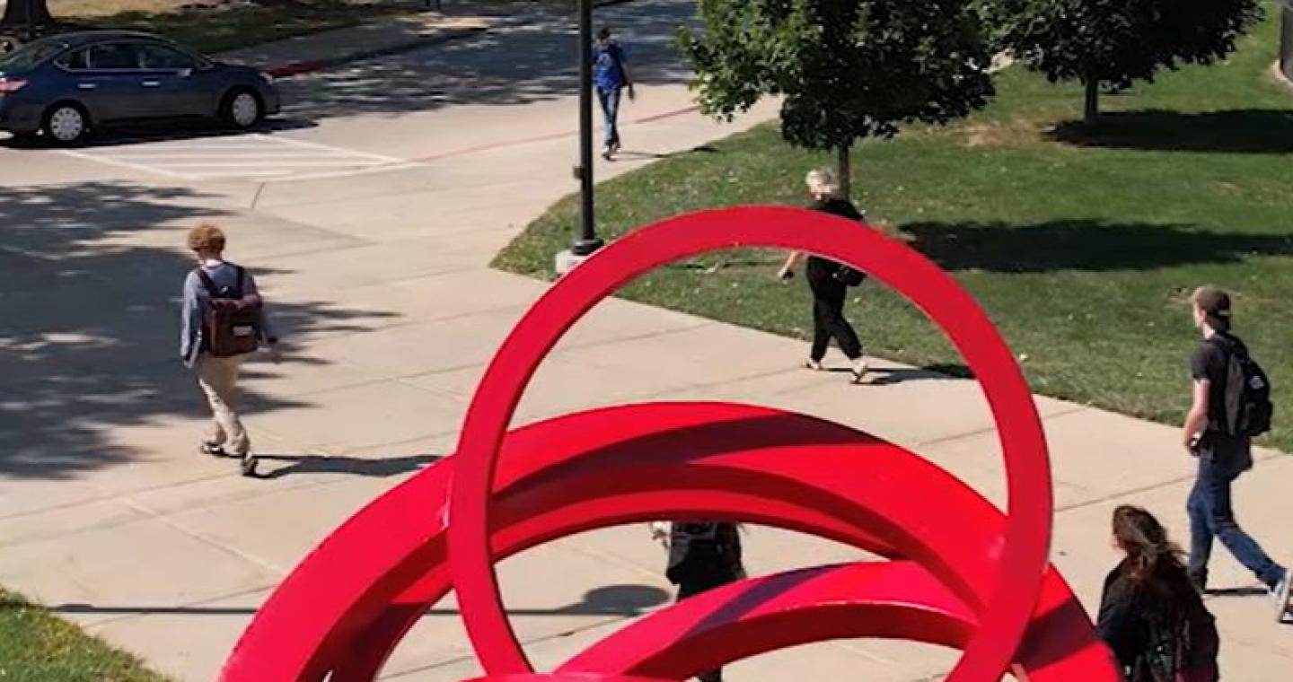 Photo of students walking to class near the LLCC sculpture.