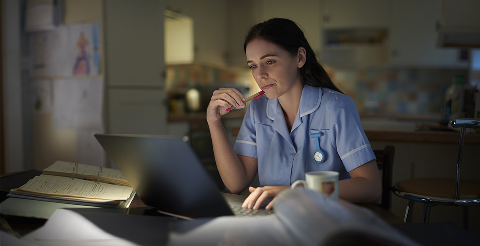 Health care professional on computer in breakroom at work