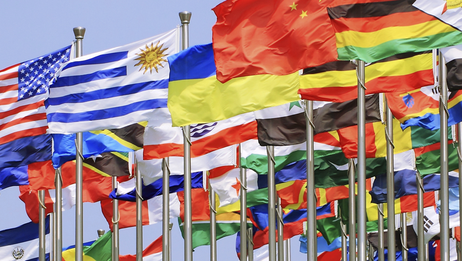 Multicolored flags from various countries blowing in the wind.