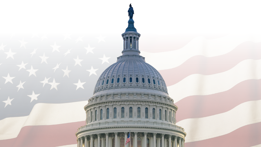 The dome of the United States Capitol Building with an American flag as the background.