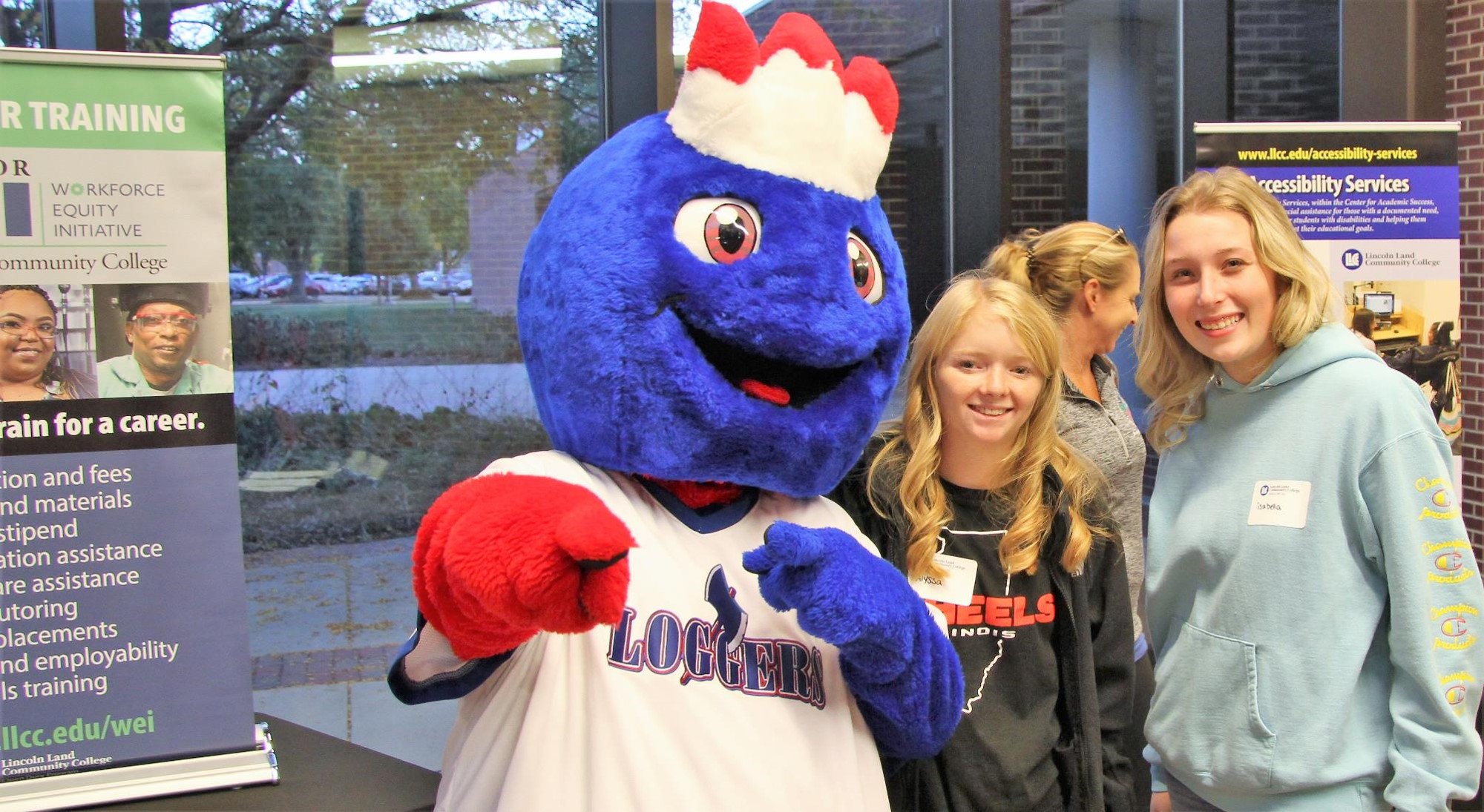 Linc standing with two prospective students in an exhibit area on campus