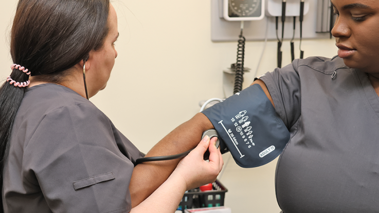 A nurse takes a patient's blood pressure.