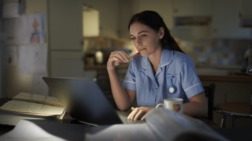 Health care professional on computer in breakroom at work