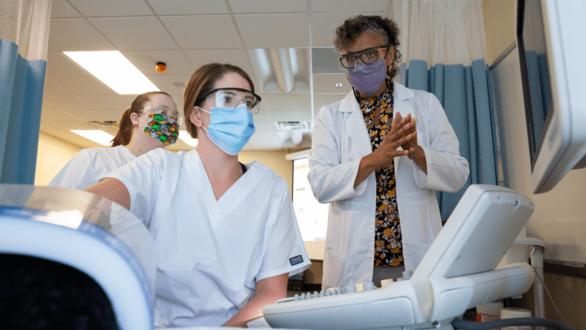 professor and student in patient room performing sonography test