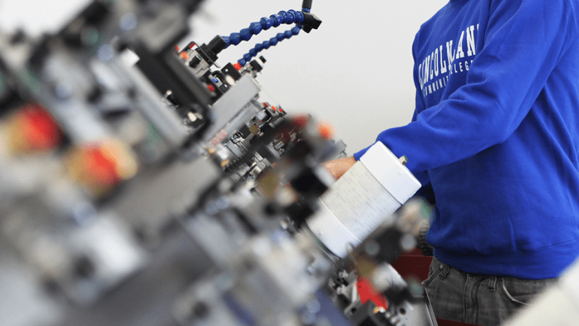 A student works on technical components of a machine.