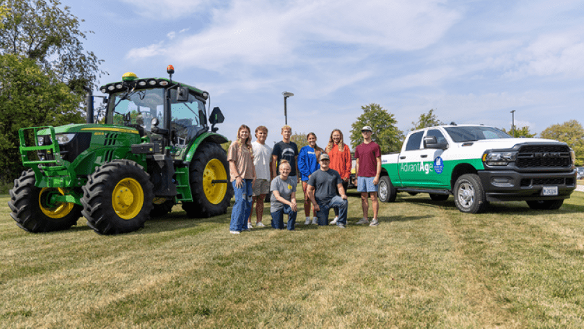 LLCC Ag students pose outside of Kreher Ag Center in front of a tractor and truck.