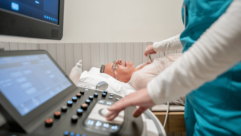 technician standing at computer scanning a patient