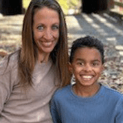 Amanda Miller and her son posing near a covered bridge in the fall.