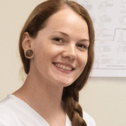 A student with brown hair in a braid poses for a photo.