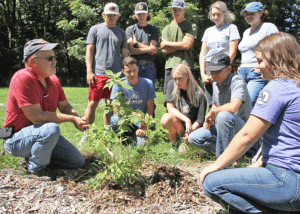 Bill Harmon talking to a group of students at the West Lake Nature Grove