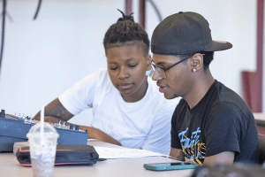 Two students look over a paper together in class